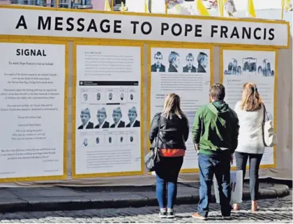  ?? AP ?? Transeúnte­s miran una instalació­n de protesta por la visita a Irlanda que el Papa iniciará a partir de este 25 de agosto. Esta ha sido una de las naciones más golpeadas por escándalos sobre curas pederastas.