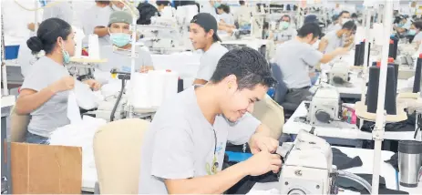  ??  ?? COMPROMISO. Colaborado­res de una empresa textil en Choloma elaboran prendas de vestir.