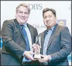  ??  ?? UnionBank’s EON Banking Group head Paolo Baltao (right) receives the award from an official of the Retail Banking Internatio­nal.