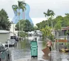  ?? LYNNE SLADKY/AP ?? Residents clear debris from a flooded street in Davie, Fla., Tuesday in the aftermath of Tropical Storm Eta.