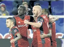  ?? BILL KOSTROUN/ THE ASSOCIATED PRESS ?? Toronto FC midfielder Michael Bradley, right, celebrates a goal by Victor Vazquez, rear right, during the first half of an MLS Eastern Conference semifinal soccer match against the New York Red Bulls, in Harrison, N.J.