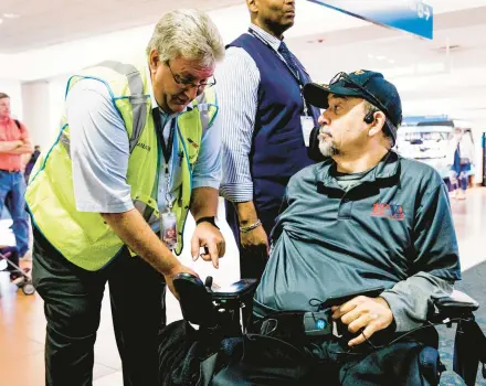  ?? ?? An airline crew member checks Charles Brown’s custom wheelchair on May 5 before he is transferre­d to an aisle chair — a special, small wheelchair that can fit into an airliner’s narrow aisles — as Brown prepares to board his first flight of the day at Palm Beach Internatio­nal Airport in West Palm Beach, Florida.