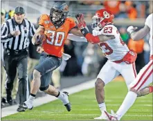  ?? [SARAH PHIPPS/ THE OKLAHOMAN] ?? Oklahoma linebacker DaShaun White (23) pushes Oklahoma State running back Chuba Hubbard out of bounds during the Bedlam game in November.