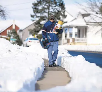  ?? RICKKINTZE­L/THE MORNING CALL ?? Mark Williams, a mail carrier for the U.S. Postal Service, walks his route Dec. 11 in Whitehall Township. A snowstorm that dumped around 10 inches of snow on Lehigh County the day before added to the stress of mail delivery in recent months.