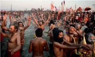  ?? AFP ?? sadhus (hindu holy men) take a dip at the holy sangam — the confluence of the Ganges, yamuna and mythical saraswati rivers — in allahabad on tuesday. —