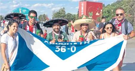  ??  ?? Cultural exchange: Mr Lorkowski, right, with the flag and some Mexico supporters in Russia.