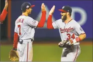  ?? Jim McIsaac / Getty Images ?? Trea Turner, left, and Bryce Harper of the Nationals celebrate after defeating the Mets Monday night at Citi Field in New York.