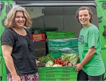  ??  ?? Kiwi Harvest’s Julie Crocker and Lynette Van Nes from Encounter Hope loading vegetables into the charity’s van.