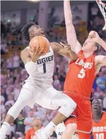  ?? ELI LUCERO/ASSOCIATED PRESS ?? Utah State’s Koby McEwen (1) elbows his way past UNM’s Joe Furstinger in the first half of their game in Logan, Utah, on Wednesday. McEwen finished with a game-high 31 points.