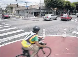  ?? Gina Ferazzi
Los Angeles Times ?? A CYCLIST rounds the corner of Cesar Chavez Avenue and St. Louis Street in Boyle Heights, where curbs have been extended and bollards erected to slow cars.