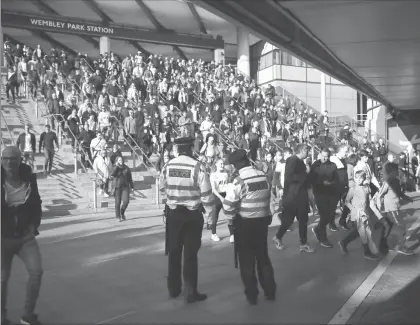  ?? Fotos Ap ?? Oficiales vigilan a la multitud fuera de la estación del Parque de Wembley después de un partido de futbol