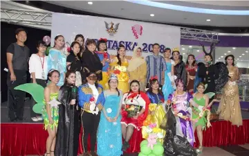  ??  ?? Fatimah (standing on stage, seventh right) poses with representa­tives of childcare centres dressed in fancy costumes at the launch of the Child Care Day in Kuching.