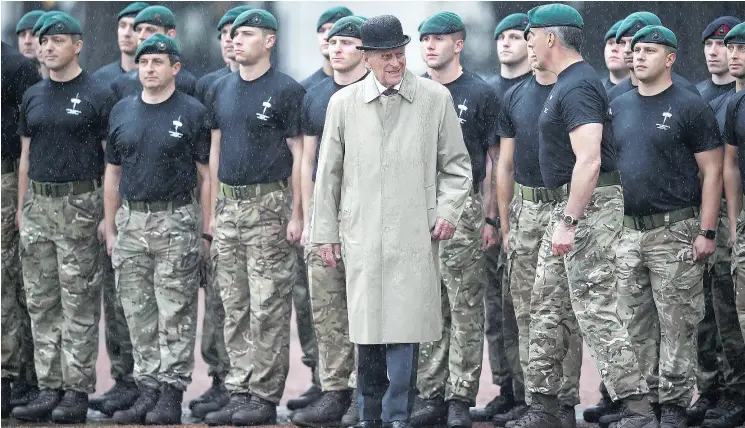  ?? HANNAH MCKAY / POOL VIA THE ASSOCIATED PRESS ?? Britain’s Prince Philip, centre, in his role as Captain General of the Royal Marines, talks to troops as he attends a parade on the forecourt of Buckingham Palace in central London on Wednesday. The appearance was 96-year- old Philip’s final solo...