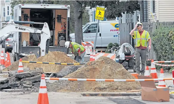  ?? MATT STONE / BOSTON HERALD FILE ?? PRICE OF DISASTER: Crews work to restore gas service and fix gas lines in Lawrence The debris of a home, top, on Chickering Road in Lawrence is seen after an explosion on Sept. 19 in Lawrence.