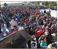  ??  ?? AP/MARCO UGARTEMigr­ants from Central America traveling in a caravan hoping to reach the U.S. border wait in line Wednesday to board buses in La Concha, Mexico. Buses and trucks are carrying some migrants farther northward.