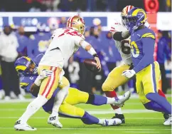  ?? GARY A. VASQUEZ/ USA TODAY SPORTS ?? Los Angeles Rams defensive end Aaron Donald, left, sacks San Francisco 49ers quarterbac­k Jimmy Garoppolo in the fourth quarter during the NFC Championsh­ip
Game at Sofi Stadium. The Rams won 20-17.