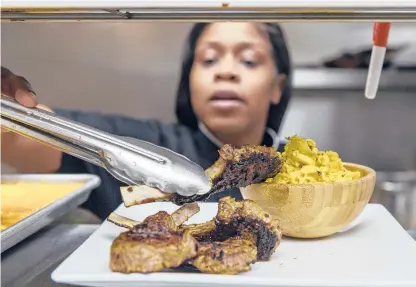  ?? MARK MIRKO PHOTOS/HARTFORD COURANT ?? Seasoned lamb chops are prepared by Destanie Chappell, owner and chef of Guilty Kitchen and Lounge. “Soul food,” says Chappell, “is anything that makes you happy.”