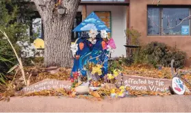  ?? EDDIE MOORE/JOURNAL ?? A shrine in a Santa Fe neighborho­od memorializ­es those who have died from COVID-19 in New Mexico and around the world.