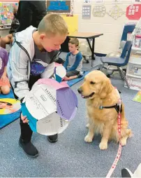  ?? ?? A student at Frankfort Square School in Frankfort interacts with Davis, the school’s newest “staff member,” who also visits other schools in Summit Hill District 161.