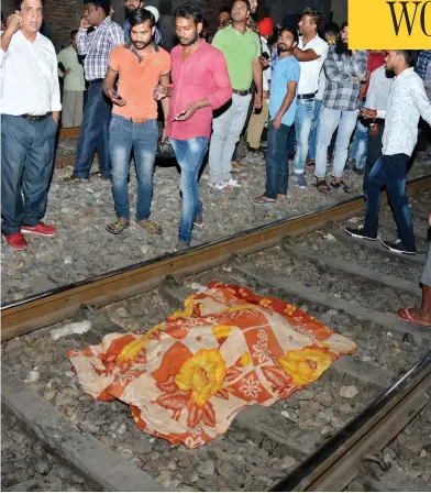  ?? PRABHJOT GILL / THE ASSOCIATED PRESS ?? A cloth covers the body of a victim on a railway track in Amritsar, India, on Friday, after a speeding train plowed through a crowd watching fireworks during a religious festival killing at least 50 people.