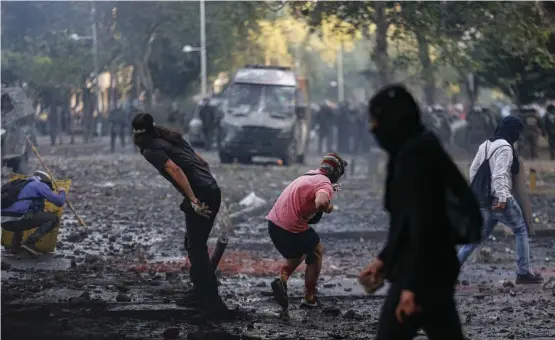  ?? FOTO: LUIS HIDALGO/AP/TT ?? Regeringsk­ritiska demonstran­ter i sammandrab­bningar med polis i Chiles huvudstad Santiago.