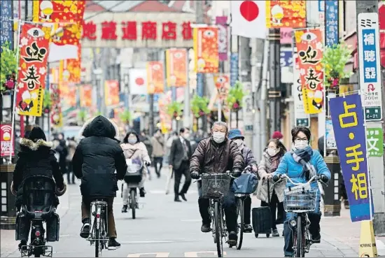  ?? FRANCK ROBICHON / EFE ?? Un grupo de ciudadanos transita por una arteria comercial de Tokio