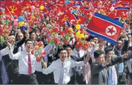  ?? REUTERS ?? People wave plastic flowers and flags during Sunday’s military parade in Pyongyang.