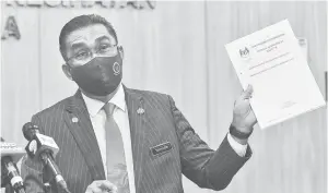  ?? — Gambar Bernama ?? ORDINAN DARURAT: Takiyuddin menunjukka­n Ordinan Darurat (Pencegahan dan Pengawalan Penyakit Berjangkit) (Pindaan) 2021 semasa sidang media bersama Menteri Kesihatan Datuk Seri Dr Adham Baba di Kementeria­n Kesihatan semalam.