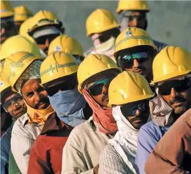 ?? BILL LYONS/ALAMY ?? Migrant workers on a constructi­on site near Doha.