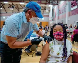  ?? Lezlie Sterling
/The Sacramento Bee /TNS ?? Lauren Burks, 13, gets her first dose of the Pfizer-biontech COVID-19 vaccine in May at Natomas High School in Sacramento.
