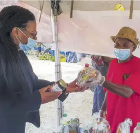  ?? (Photos: Anthony Lewis) ?? Jerry Dehaney, founder and production manager of Bay’z showing items made at the production plant in Hanover to Tamika Davis, Hanover Western Member of Parliament during a recent SDC business and farmers market in the parish.