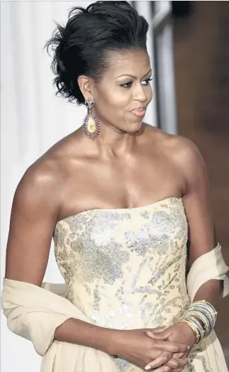  ?? Brendan Smialowski Getty Images ?? FOR HER first state dinner in 2009, Michelle Obama picks a sleeveless gown from Naeem Khan.