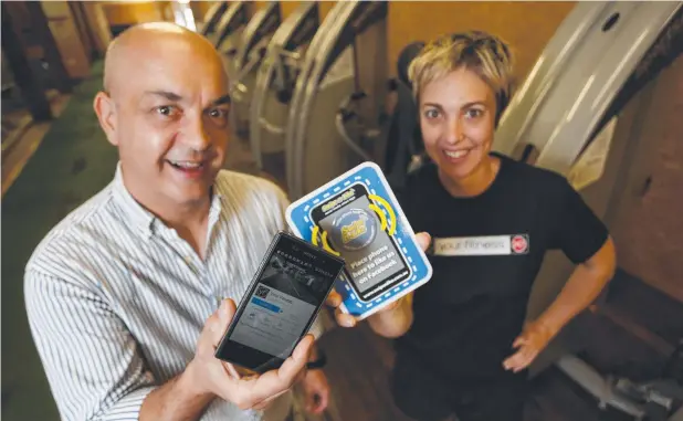  ?? Picture: STEWART McLEAN ?? INSTANT CONNECTION: Nic Zymaras with Your Fitness gym owner Marsha Rohweder who has used the Swipe-n-Like technology to also allow gym users to swipe on the machines and bring up a how-to-use video tutorial.