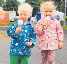  ?? Photo / Ilona Hanne ?? Cousins Cooper Old (left) and Bella Meijer, both 3, were not letting a bit of rain on Sunday stop them enjoying the classic summertime treat of a soft serve icecream. The pair, both from New Plymouth, were at the A&P Show with their families and were dressed for the weather in smart gumboots and raincoats.