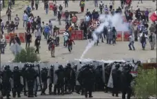  ?? AP PHOTO/LUIS ALBERTO CRUZ HERNANDEZ ?? Riot police battle with protesting teachers who were blocking a federal highway in the state of Oaxaca, near the town of Nochixtlan, Mexico, on Sunday.