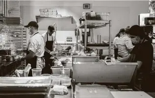  ?? Jessica Phelps / Staff photograph­er ?? Staffers prepare lunch orders at Tre Trattoria. The restaurant won’t be changing anything regarding mask-wearing despite Gov. Greg Abbott’s order ending the statewide mask mandate.