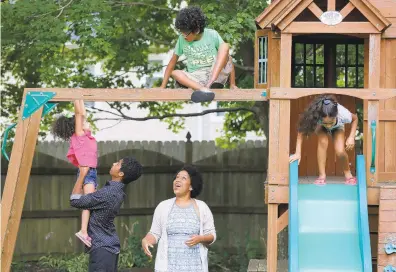  ?? JONATHON GRUENKE/STAFF ?? Joy Naik, center, watches as her children, from left, Olivia, 3, Sahar, 14, Mihir, 13, and Ashraya, 8, play in their backyard in Chesapeake Thursday evening. Joy Naik has made the decision to have her children complete online learning for the upcoming school year.