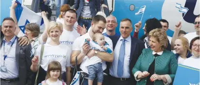  ?? (Olivier Fitoussi) ?? IMMIGRATIO­N AND ABSORPTION Minister Sofa Landver greets a baby who arrived with a group of Ukrainian olim yesterday.