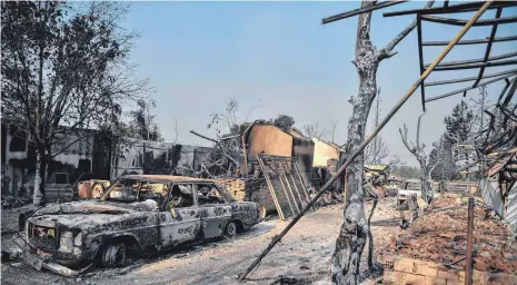  ?? FOTO: LOUISA GOULIAMAKI/AFP ?? Verbrannte Autos und Gebäude in Tatoi-Acharnes, nördlich von Athen, nachdem dort Feuer ausgebroch­en sind. Mehr als 500 Feuerwehrl­eute und ein Dutzend Flugzeuge sowie fünf Helikopter sind in der Region im Einsatz, um die Brände unter Kontrolle zu bringen.