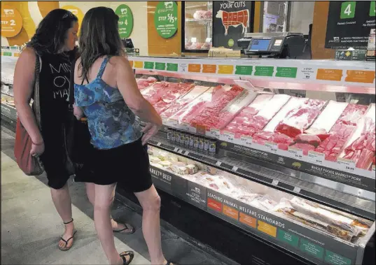  ?? David Guzman Las Vegas Review-Journal ?? Customers in the meat and poultry department at the Summerlin Whole Foods Market. Amazon, which recently acquired Whole Foods, is experiment­ing with a plan to let consumers pay for items without standing in line.