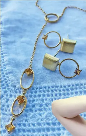  ??  ?? SHINING, SHIMMERING: Earrings and a ring featuring rutilated quartz from the Kara collection, Cacay’s favorite (above left). Citrine lariat necklace from the Artemis collection (above). Pearls are featured in the Kandinsky collection (left).