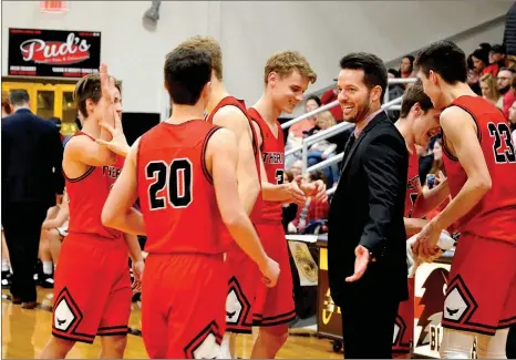  ??  ?? Fellow Blackhawks and head coach Trent Loyd gave a hand as the Blackhawk starters came off the court for a time out.