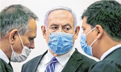  ?? PHOTO: AFP ?? Charged: Israeli Prime Minister Benjamin Netanyahu (centre) speaks to his lawyer in court before the trial started.