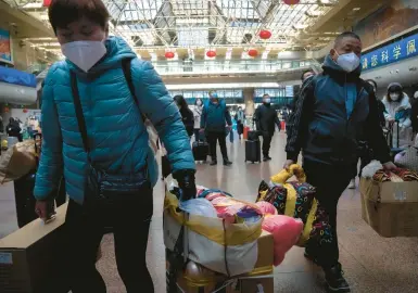  ?? MARK SCHIEFELBE­IN/AP ?? With Lunar New Year approachin­g, travelers pass through the Beijing West Railway Station on Wednesday in Beijing.