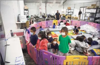  ?? Dario Lopez-Mills / Associated Press ?? Young unaccompan­ied migrants from ages 3 to 9 watch television inside a playpen at the U.S. Customs and Border Protection facility, the main detention center for unaccompan­ied children in the Rio Grande Valley, in Donna, Texas, on Tuesday.