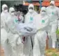  ?? REUTERS FILE ?? Doctors and relatives wear protective gear as they carry the body of a Nipah victim in Kozhikode, Kerala.
