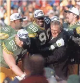  ?? PACKER PLUS FILES ?? GM Ron Wolf gets a hug from Sean Jones after the Packers won the NFC championsh­ip game against the Panthers, 30-13.
