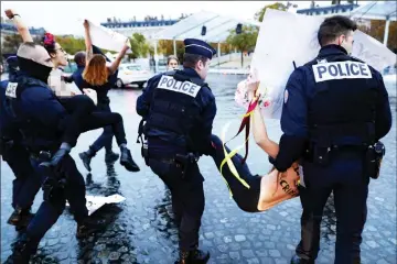  ??  ?? Members of feminist movement Femen are evacuated by the police after demonstrat­ing in front of the Arc de Triomphe, as several leaders are to arrive in Paris on the eve of the commemorat­ions of WWI armistice centenary. — AFP photo