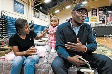  ?? ELISE AMENDOLA/AP PHOTOS ?? Prince Pombo, right, of the Congo, seen with his wife, left, and daughter, are living in an emergency shelter in Maine.