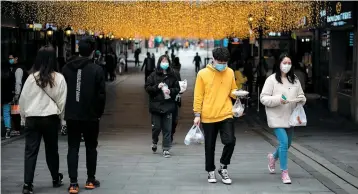  ?? PHOTO AFP ?? Les habitants de Wuhan commencent à circuler dans les rues et commerces, mais portent des masques de protection, puisque la menace de la COVID-19 est toujours là.